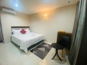 a bedroom with a bed and a chair in it at Motel Seri Mutiara in Kuah
