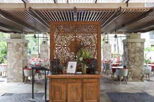 een patio met tafels en stoelen en een groot scherm bij Temple 304 Modern Spacious Palm Cove Resort in Palm Cove