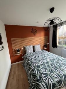 een slaapkamer met een bed met een zwart-wit dekbed bij Beau Loft room proche mont saint Michel jaccuzi illimité en plein centre Avranches in Avranches