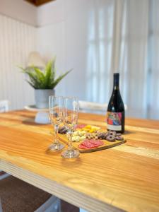 una mesa con dos copas y una botella de vino en Casa Toscana junto al río, en El Bolsico