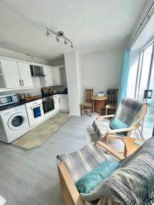 a living room with a couch and chairs and a kitchen at Apartment in central Exmouth in Exmouth