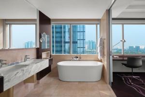 a bathroom with a large tub and a large window at Le Méridien Saigon in Ho Chi Minh City