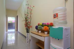 Cette chambre dispose d'un comptoir fleuri et d'un réfrigérateur. dans l'établissement RedDoorz near Tirtonadi Park Solo, à Kadiporo