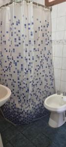 y baño con aseo y cortina de ducha. en Alquiler turístico en Maipú
