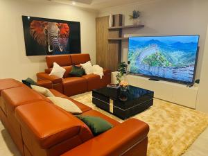 Una sala de estar con un sofá y un televisor de pantalla plana. en Skylight Splendour!, en Perth
