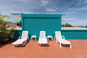 a group of white chairs and a screen on a roof at HOUSE OF HAPPINESS in Thongsala