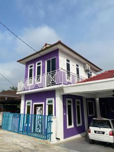 een paars en wit huis met een auto voor de deur bij Dan's Homestay Bangau in Temerloh