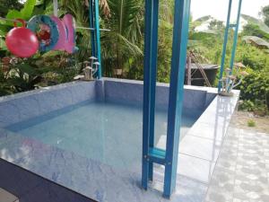 een zwembad met een blauwe paal in het midden bij Dan's Homestay Bangau in Temerloh