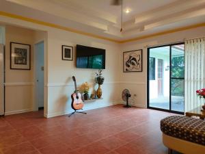 salon z gitarą i telewizorem w obiekcie DMC2 Residence Panglao w Panglao City