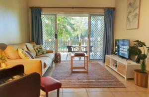 a living room with a couch and a tv at Benayah 3 - Family friendly - Wongaling Beach in South Mission Beach