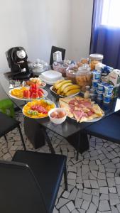 einem Tisch mit verschiedenen Lebensmitteln auf in der Unterkunft Angolo Relax Camere king in Rimini