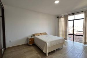a bedroom with a bed and a large window at Hermoso y amplio departamento in Tarija