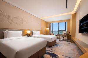 Voodi või voodid majutusasutuse Wyndham Grand Plaza Royale Yuzhou Xiamen Wuyuan Bay toas