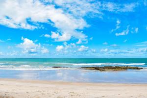 a beach with rocks in the water and a blue sky at Carneiros Beach Resort - Flats Cond à Beira Mar in Praia dos Carneiros