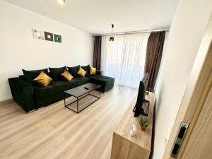a living room with a green couch and a television at Urban Plaza Astra - Rise Private Apartments & Suites in Braşov