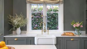 a kitchen with a sink and a window with flowers at Werona Cottage - enchanting home in Burrawang +13 photos