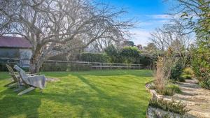 a park bench sitting in the middle of a yard at Werona Cottage - enchanting home in Burrawang +13 photos