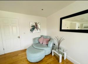 sala de estar con silla azul y espejo en Ballina Town Centre Duplex Apartment, en Ballina
