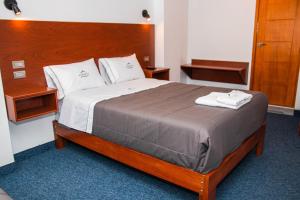 um quarto com uma cama grande e uma cabeceira em madeira em Hotel Turístico Everest em Huaraz