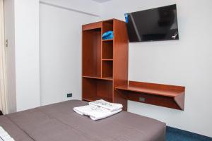 a bedroom with a bed with a tv on a wall at Hotel Turístico Everest in Huaraz