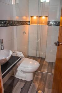 a bathroom with a toilet and a sink and a shower at Hotel Turístico Everest in Huaraz