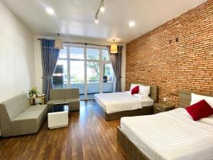 um quarto de hotel com duas camas e uma parede de tijolos em Vy Da Backpacker Hostel em Cidade de Ho Chi Minh