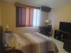 1 dormitorio con cama, ventana y escritorio en Confort, en Manta