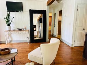 ein Wohnzimmer mit einem weißen Stuhl und einem Spiegel in der Unterkunft 10 Mins Downtown 20 Mins Airport PET FRIENDLY in Decatur + 25 Fotos