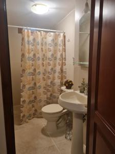 曼塔的住宿－Confort，浴室设有卫生间、水槽和淋浴帘