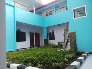 ein blaues Gebäude mit einer Treppe davor in der Unterkunft Welirang 20B Homestay - Max 2 Orang Per Kamar in Malang