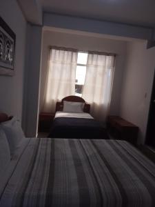 a bedroom with two beds and a window at Hospedaje Moralillos in Yurimaguas