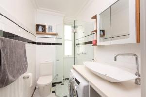 Baño blanco con lavabo y aseo en Tranquil 1 Bedroom Apartment - Rushcutters Bay Self-Catering en Sídney