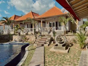 a house with a swimming pool next to a house at Blue Sky Villa Ceningan in Nusa Lembongan