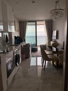 Il comprend une cuisine et un salon offrant une vue sur l'océan. dans l'établissement Copacabana jomtien beach high floor, à Jomtien Beach