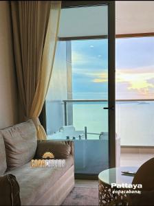 a living room with a couch and a bath tub at Copacabana jomtien beach high floor in Jomtien Beach