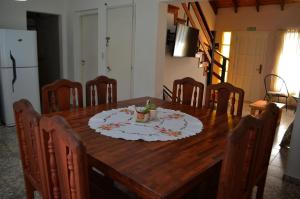 una mesa de comedor de madera con sillas y un plato. en ESPAÑA CENTRICO en El Bolsón