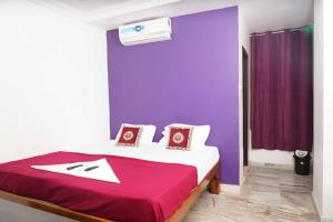 a bedroom with a purple wall and a bed at Sea side guest house vizag in Visakhapatnam