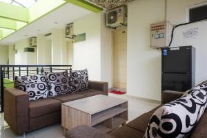 een woonkamer met een bank en een koelkast bij Urbanview Syariah Kadarman Home Laweyan by RedDoorz in Grogol