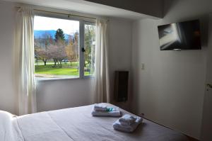 a bedroom with a bed and a window with towels on it at ESPAÑA CENTRICO in El Bolsón