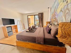 a bedroom with a large bed with two stuffed animals on it at Zibá Home Suites in Lamai