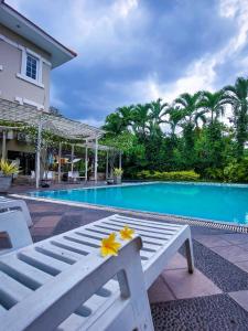 a white bench sitting in front of a swimming pool at Country Heritage Hotel in Surabaya