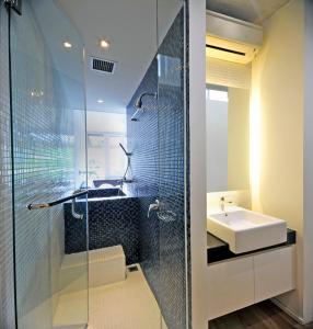 een badkamer met een glazen douche en een wastafel bij Ecoloft Jababeka Golf in Cikarang