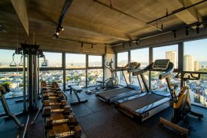 a gym with cardio machines and a view of the city at Luxtery Hotel & Spa in Da Nang