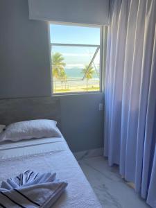 um quarto com uma janela com vista para a praia em Enseada Beach Hotel no Guarujá