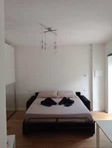 1 dormitorio con 1 cama en una habitación con lámpara de araña en Il monolocale, en Bosisio Parini