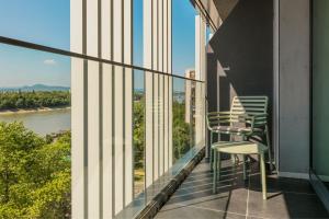 einen Balkon mit Stühlen und Flussblick in der Unterkunft Four Points by Sheraton Budapest Danube in Budapest