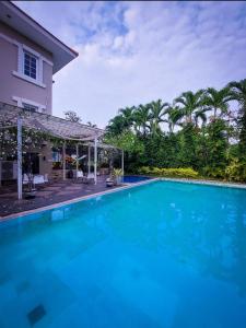 Country Heritage Hotel في سورابايا: مسبح ازرق كبير بجوار منزل