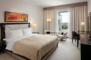 a hotel room with a large bed and a desk at Grand Hotel River Park, a Luxury Collection Hotel, Bratislava in Bratislava