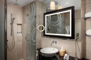 a bathroom with a sink and a shower with a mirror at Grand Hotel River Park, a Luxury Collection Hotel, Bratislava in Bratislava