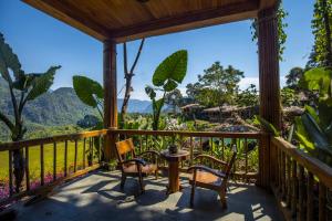 eine Veranda mit Stühlen und einem Tisch mit Aussicht in der Unterkunft Pu Luong Natura in Pu Luong